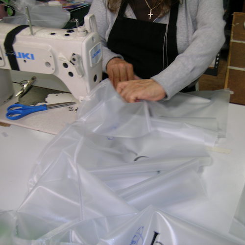 Person sewing clear vinyl industrial curtain